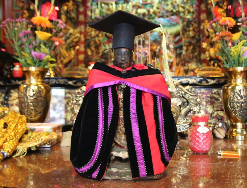 圖說：廟方替神農大帝披上量身訂做的中正大學博士袍。