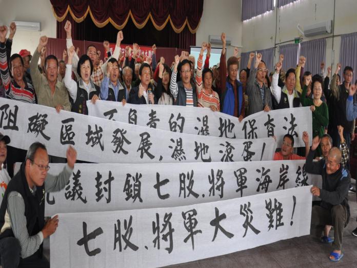 反對營建署將七股與將軍廢鹽灘劃為濕地，地方民眾拉白布條抗議。