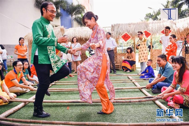 在越南胡志明市一所國際學校，師生在春會上玩跳竹竿游戲。