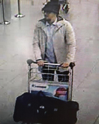 比利時首都布魯塞爾機場22日發生連環爆炸案，當局公布監視器拍到的嫌犯畫面，顯示1名戴帽男推著裝有行李的推車通過安檢區。（共同社提供）中央社 105年3月23日