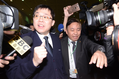 遭長榮航空臨時董事會撤換董事長一職的張國煒（左）12日傍晚搭機回台，他與機組人員一起走出艙門，面對大批媒體的守候，表情有些五味雜陳，但是嘴角仍微幅上揚，點頭向媒體致意。中央社記者邱俊欽桃園機場攝　105年3月12日