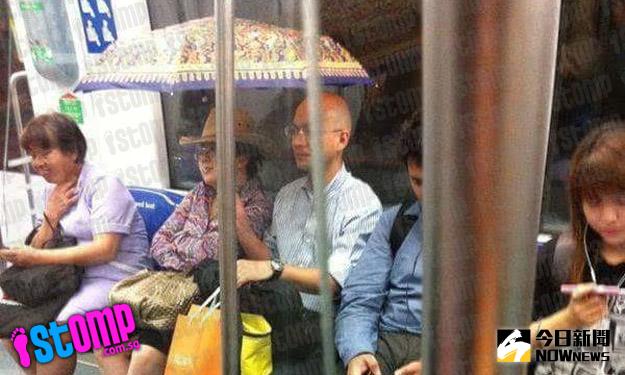 ▲新加坡一名男子在地鐵車廂內撐傘，引起網友熱烈討論。（圖／翻攝自singaporeseen）