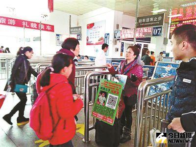 張雪霞走到哪裡，都會在胸前掛一個尋找兒子的綠色牌子。