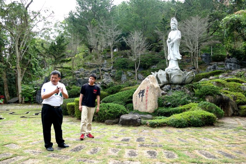 國姓鄉泰雅渡假村總經理李吉田(左)指出，泰雅小秘境「滴水觀音」景點，有座以整顆巨型泉州白石所雕刻而成的觀音菩薩像，是民國85年由惟覺老和尚親自督導建造。