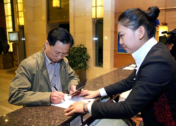 4月30日24時許，陳生（左）在北京民族飯店填寫增值稅發票客戶資訊表。