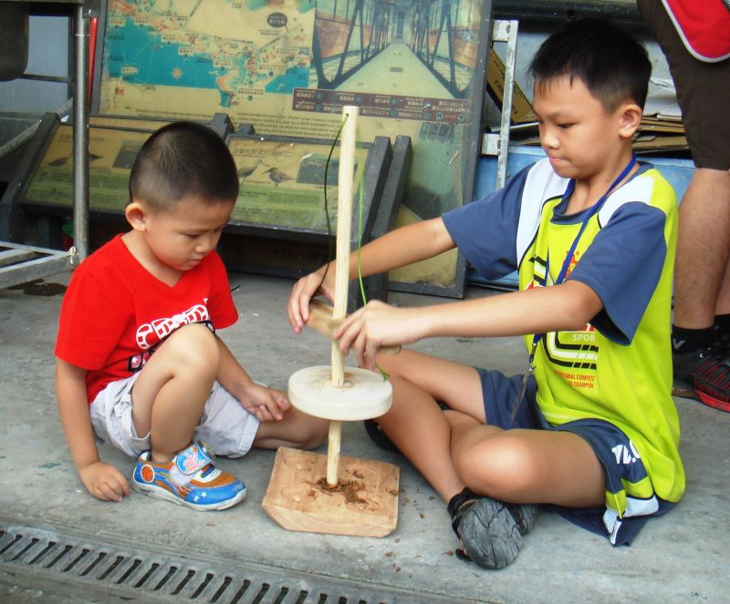 ▲營隊小朋友體驗「鑽木取火」。（圖／十三行博物館提供）