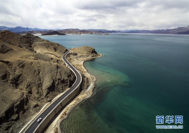 汽車沿著班公湖畔的公路穿行,湖邊依然隱約可見曾經崎嶇泥濘的舊路(4月28日攝)。