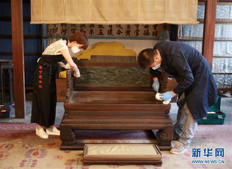 6月11日，故宮博物院的工作人員對養心殿內的一把椅子進行裝箱前除塵處理。