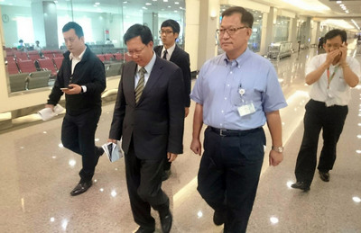 2日一早搭機出國的桃園市長鄭文燦（左2），3日提早返國面對桃機淹水問題。他在機場時受訪表示，「交通部、桃機與市府，應建立溝通平台，面對與解決問題」。中央社記者卞金峰攝 105年6月3日