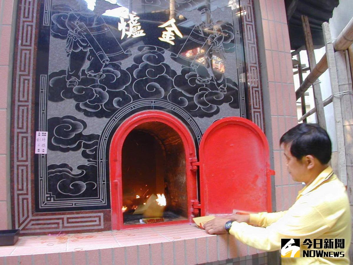 ▲信眾將金紙整疊放在爐口，氣流就會把金紙一張張自動吸入爐內焚燒。〈圖／記者黃玿琮攝〉