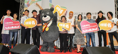 北市府於12日舉辦世大運主題曲徵選活動記者會，並邀請樂團「TRASH」和「猴子飛行員」主唱楊聲錚到場演唱。會後世大運吉祥物熊讚與世大運執行長蘇麗瓊（右6）、徵選活動評審團副召集人陳建騏（右3）和樂團合影。中央社實習記者蘇郁晴攝 105年7月12日