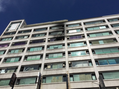 新店區中正路清晨某10樓層樓建築物火警，冒出濃煙的8樓是老人安養院，警消全力搶救下仍有多名老人命危送醫。（低解析圖片）中央社記者郭日曉攝  105年7月6日