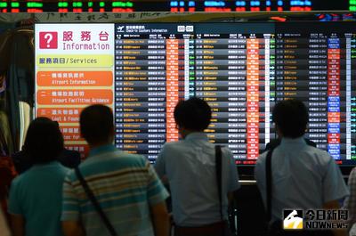 尼伯特颱風襲台，但桃園機場8日上午未出現強風豪雨，部分旅客考量班機隨即恢復，也提早前往機場候機，緊盯航班看板動態訊息。中央社記者邱俊欽桃園機場攝　105年7月8日