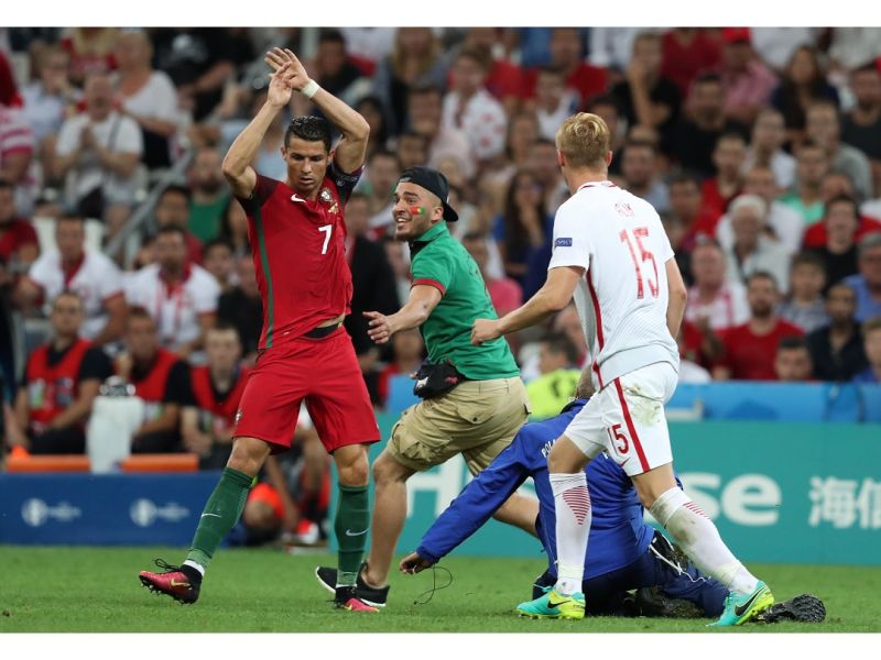 綠衣的瑞士球迷Shamshir Karimi闖進賽場為擁抱葡萄牙隊長C羅（左）。（圖／美聯社／達志影像）