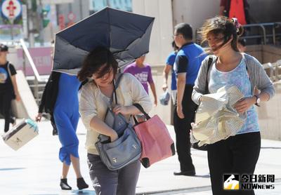 中央氣象局6日下午發布強烈颱風尼伯特海上颱風警報，颱風將對巴士海峽及台灣東部海面構成威脅，台北市午後太陽高掛，高溫又刮風，行人撐傘被掀反。中央社記者施宗暉攝  105年7月6日