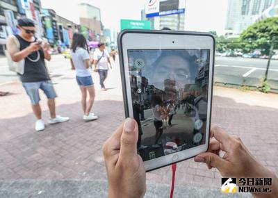 在全球爆紅的手機遊戲精靈寶可夢（Pokemon GO），6日終於在台灣區開放下載，許多人爭相下載，圖為光華商場周邊的民眾在街上體驗遊戲樂趣。中央社記者謝佳璋攝 105年8月6日