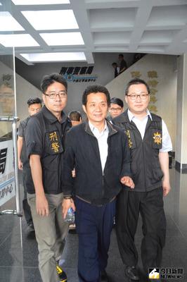 刑事局中部打擊犯罪中心12日傳喚涉嫌教唆槍殺嘉義市保警林進忠的嘉義縣竹崎鄉長王焜弘（前中），對於是否涉案，王焜弘僅以微笑帶過；另對於外傳裸照引殺機一事，警方表示不知情。中央社記者廖壬楷攝 105年4月12日