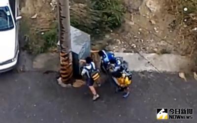 中度颱風梅姬來襲，嘉義縣政府27日放半天，有網友在綠豆嘉義人臉書網頁張貼一段影片，嘉義縣4名國小學童中午放學時，被強風吹的無法前進，只能躲在電線桿後方。（翻攝綠豆嘉義人臉書）中央社記者黃國芳傳真 105年9月27日