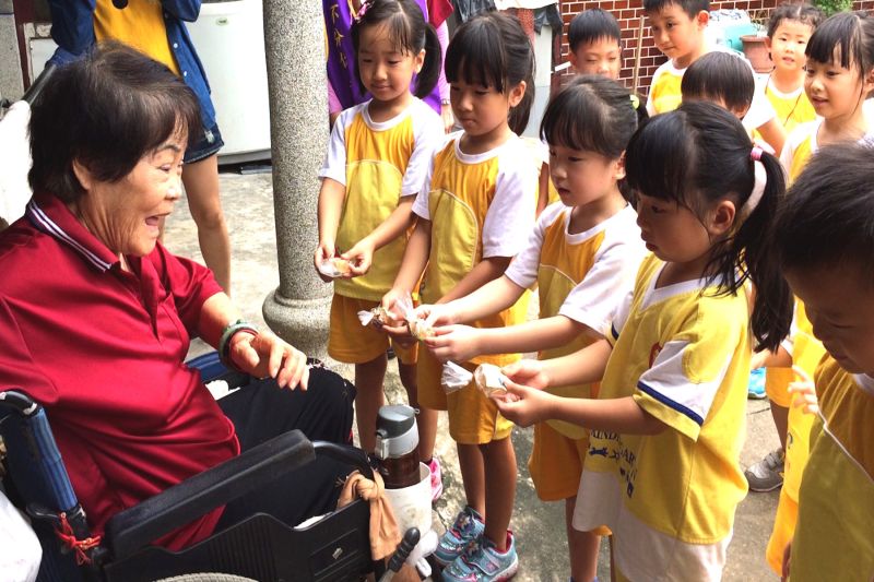 ▲小博士幼兒園小朋友將甜餅送給弱勢長者，長者笑的閤不攏嘴。