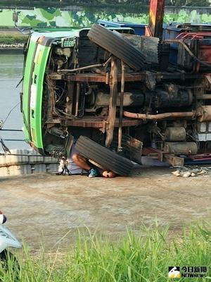 北市消防局1日下午4時31分獲報，一輛吊車在大佳河濱公園執行吊掛業務時，疑似吊掛不慎側翻，導致1名年約50歲的工人遭壓傷，警消到場後發現他已命危，仍在搶救當中。（民眾提供）中央社記者游凱翔傳真　105年9月1日