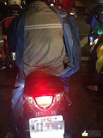 ▲馬路中上演咒怨，騎士雨衣內驚見小男孩探頭。（圖／翻攝自爆料公社）