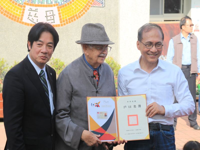 行政院長林全將身分證及戶口名簿交給甘惠忠神父，並肯定甘惠忠神父對台灣的貢獻，台南市長賴清德在場見證。