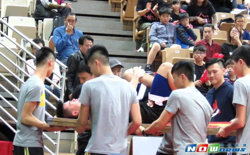 ▲韓杰諭被隊友以廣告看板抬至場外。（圖／記者林志儒攝）