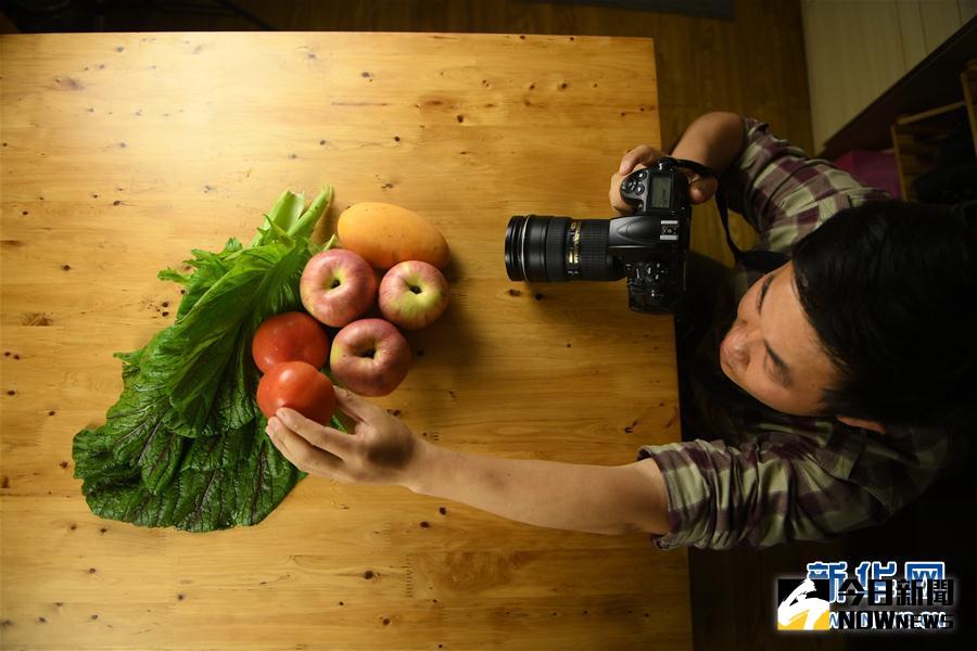 在江西南昌，農產品攝影師秦方在給蔬菜瓜果拍照。