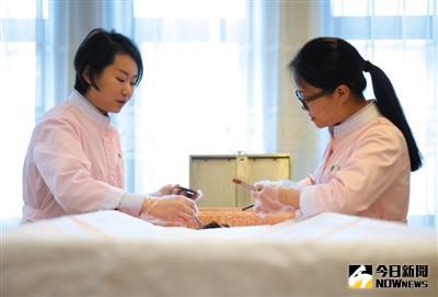 3月29日，北京八寶山殯儀館『青清女子工作室』整容師曲傑（右）和袁榕（左）正在為逝者整理遺容。