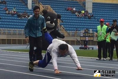 台北市長柯文哲（前）7日視察世大運田徑場，與田徑國手楊尉庭、陳傑試跑跑道，柯文哲不慎跌倒，隨後馬上站起來衝向終點線。中央社記者劉建邦攝  106年4月7日