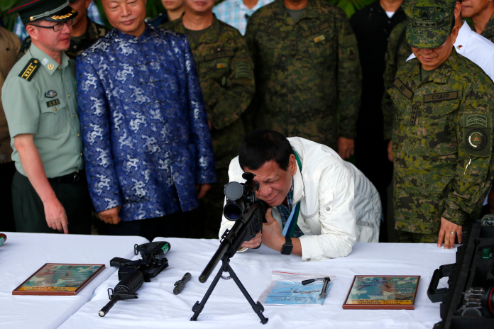 菲律賓總統在武器移交儀式上試用中國大陸製造的槍枝。（圖／達志影像／美聯社）