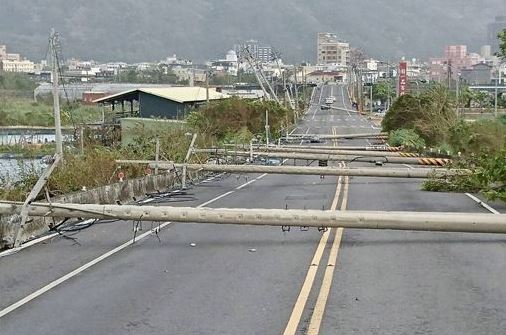 宜蘭縣頭城至竹安路段的濱海公路，有20根電線杆不勘強風吹擊倒塌，目前仍在搶修中。（圖／社會中心翻攝）