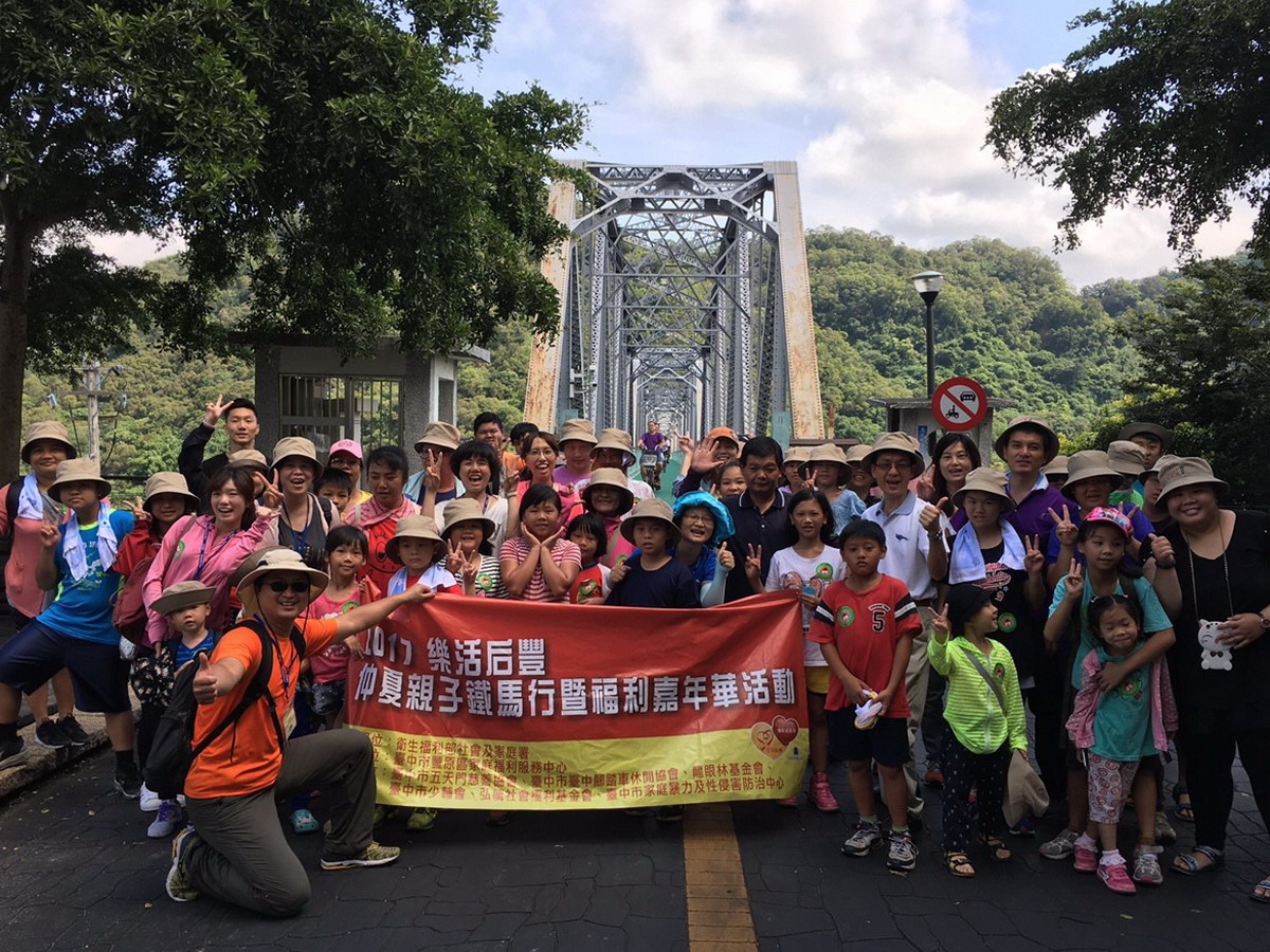 仲夏后豐親子鐵馬行活動，逾百位家長與孩童在花樑鋼橋前合影。（圖／豐原區家庭福利服務中心提供2017.7.15）