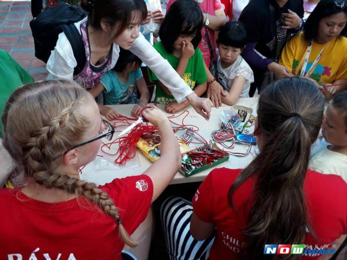 孔雀匈牙利國家兒童民俗舞蹈團小團員與遊客一起編製手環（圖／記者李清貴攝 , 2017.07.09）