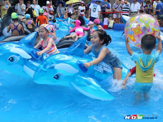 許多家長帶著小朋友到葫蘆墩文化中心，在氣墊水池中盡情戲水玩樂。〈圖／記者黃玿琮攝，2017.7.2〉