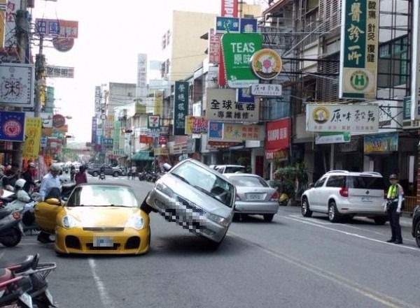 ▲一名福特駕駛行車時為撿東西不慎走偏，竟直接「騎」上停在路旁的保時捷。（圖／社會中心翻攝）