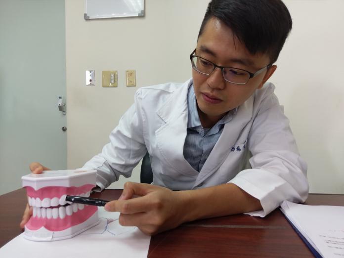 牙科醫師楊宗融說明，利用齒間乳頭兩邊將牙齦覆蓋，就可治癒吃冰冷食物痠痠感。〈圖／衛福部豐原醫院提供〉