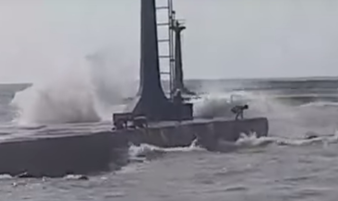 民眾低伏著身子在大浪中撈螃蟹，畫面怵目驚心。（圖／社會中心翻攝）