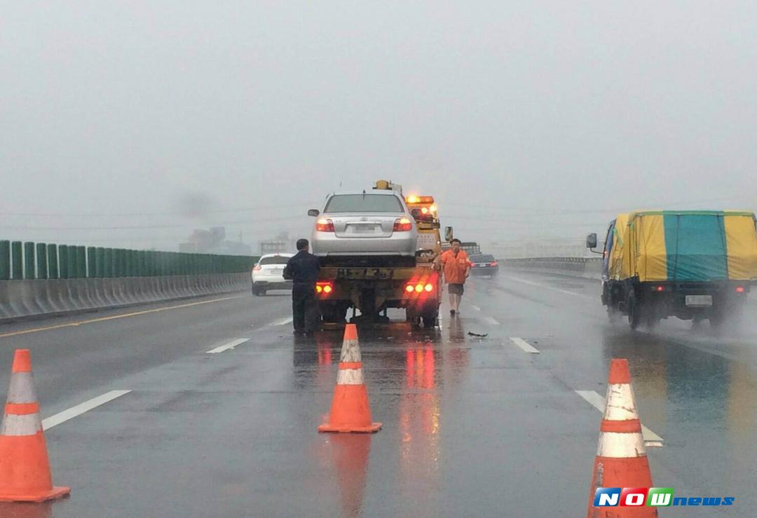 國道3號中部路段大雨中傳出多起追撞事故，員警冒著安危擺放三角錐維護安全。（圖／記者陳雅芳翻攝，2017.8.10）