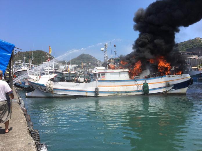 消防人員將起火的漁船拉到岸邊搶救。（圖／記者李清貴翻攝 , 2017.08.02）