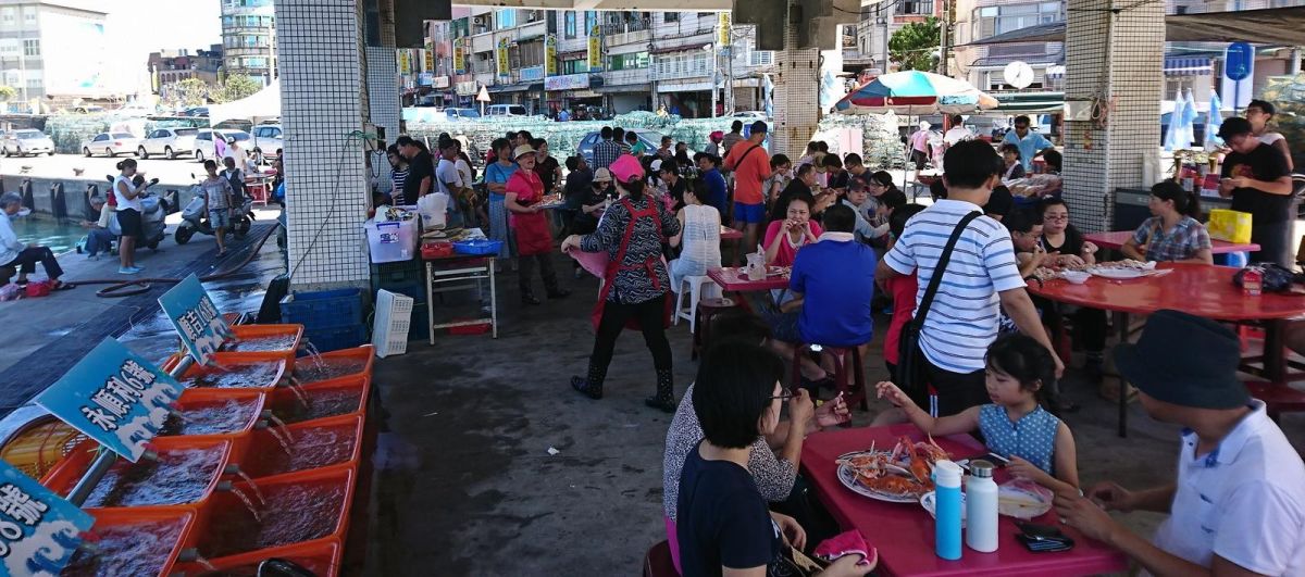 ▲萬里漁民們特別在野柳漁港藍色公路的候船亭下舉辦「野柳假日活蟹市集」，漁夫們在野柳漁港擺攤販售剛從漁船卸貨的生猛活蟹。（圖／新北市政府漁業及漁港事業管理處提供）