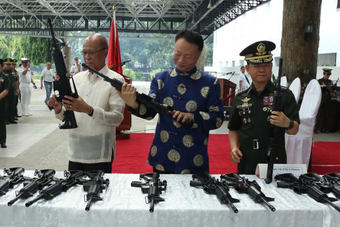 ▲中國駐菲大使趙鑒華（中）5日代表中國國防部捐贈3000支CQ-A5b突擊步槍、90支狙擊槍瞄準器以及300萬發子彈給菲律賓軍方，由菲國國防部長羅倫沙納（左）和參謀總長安紐（右）代表接受。（菲軍方公共關係處AFP-PAO提供）中央社記者林行健馬尼拉傳真  106年10月5日