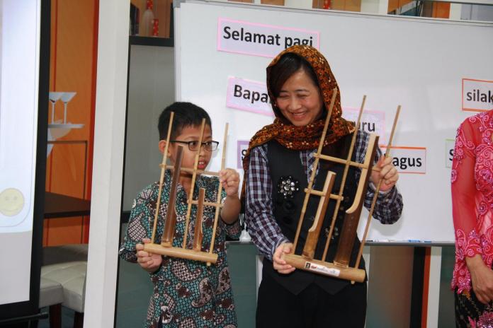 ▲教育局長林奕華入班與學生體驗印尼語教學的活動，並學習傳統的印尼竹樂器「昂格隆」（Angklung）。（圖／新北市政府教育局提供）