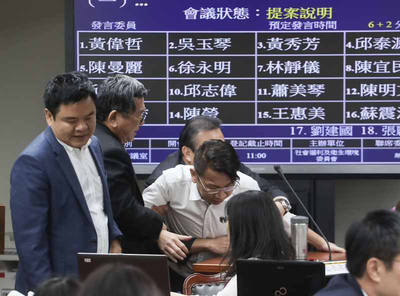 ▲立法院20日審查勞動基準法部分條文修正草案，時代力量立法院黨團總召徐永明（中白襯衫者）主張復議期未過，不能違法開會，霸占質詢台。晚間8時民進黨籍立委將徐永明拉出委員會，繼續議事。中央社記者裴禛攝106年11月20日