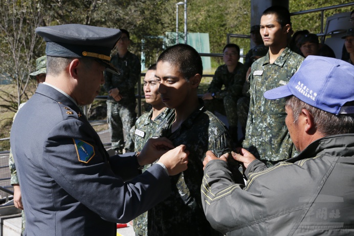 ▲ 陸軍特訓中心指揮官苑中校15日頒發突擊兵榮譽徽，並由親友為其子弟別上突擊兵臂章，見證榮耀。（軍聞社記者卓以立攝）