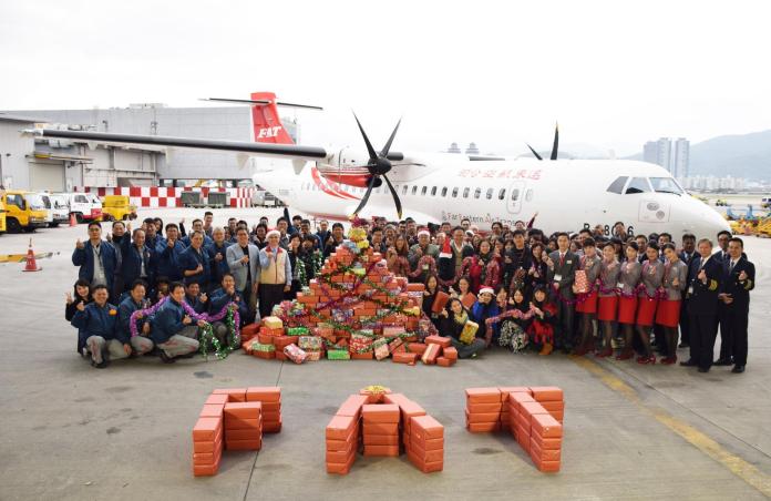 ▲遠東航空今年引進2架ATR72-600客機，所以特別選在ATR飛機前面，將員工捐贈的鞋盒禮物排成聖誕樹的形狀，甚至還排出「FAT」英文字樣。（圖／遠航提供）
