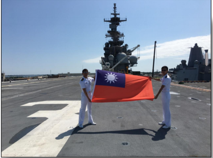 ▲兩位艦訓學生在美軍艦飛行甲板上，大方展示中華民國國旗，並合影致敬。（圖／翻攝自公務出國報告）