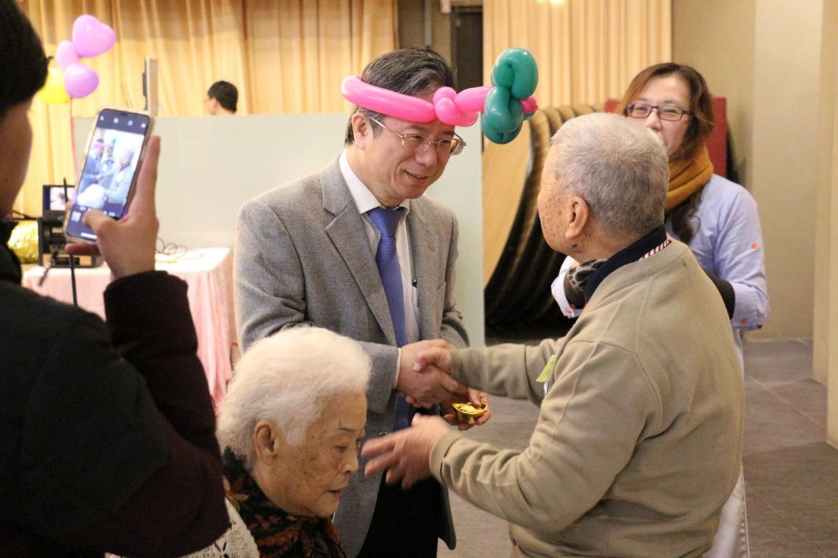 ▲嘉基姚維仁院長頭戴紅、綠色氣球帽，致贈「祝福金元寶」。〔圖／嘉義基督教醫院提供，2018.02.02〕