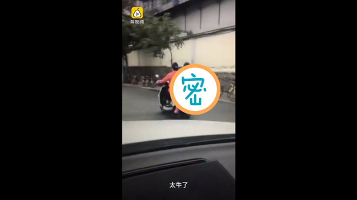 ▲中國大陸瘋傳一則影片，一名女學生背對機車駕駛念書，網友表示「這樣太危險」。（圖／翻攝自Youtube）