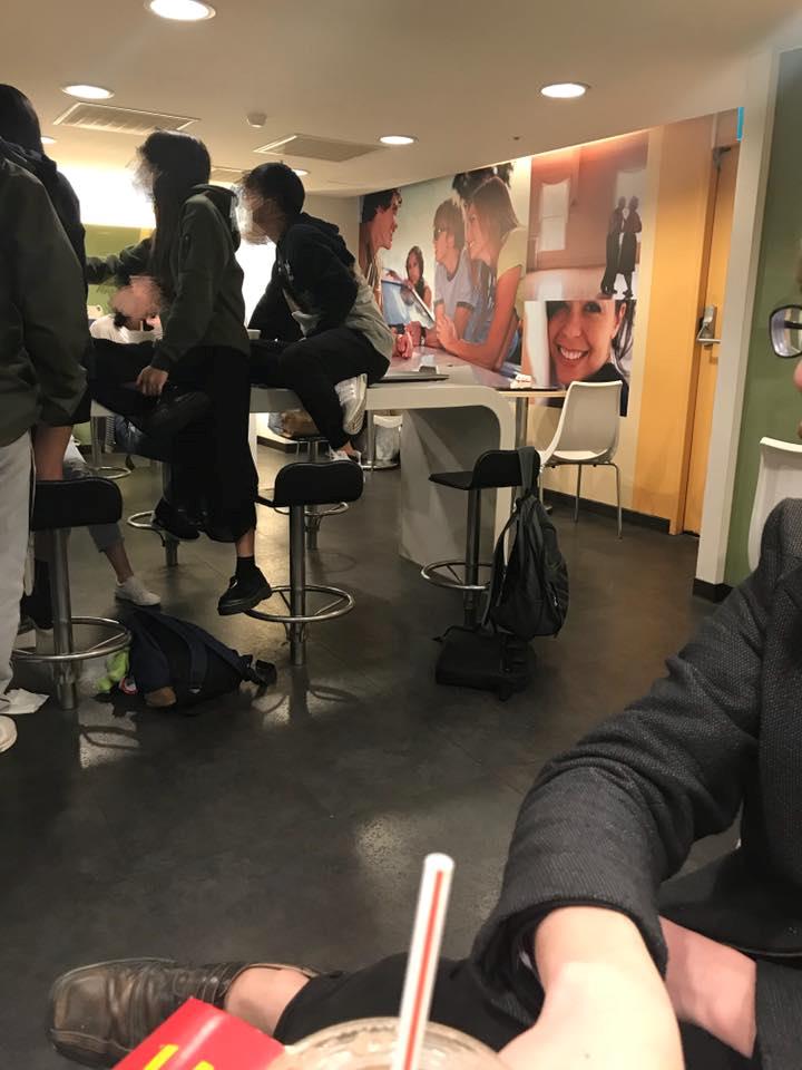 ▲學生在麥當勞用餐時一屁股直接坐在桌子上，腳還踩著椅子。（圖／翻攝自《爆料公社》）